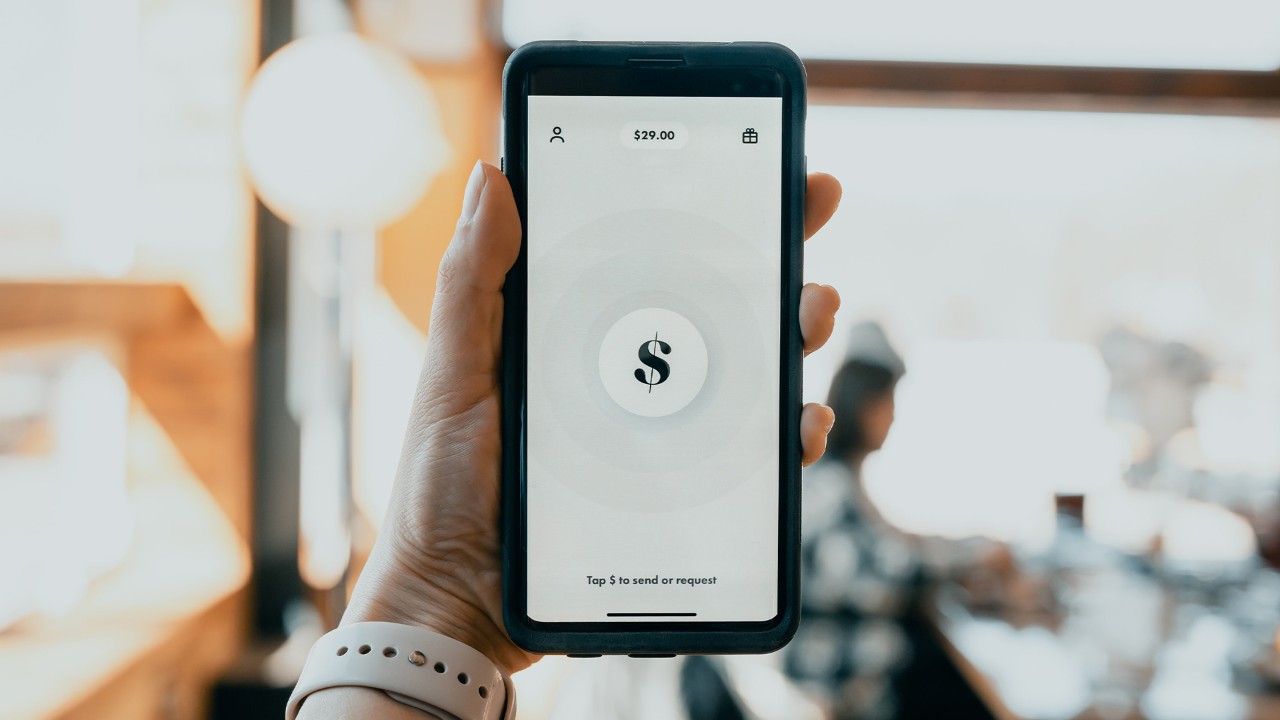 A person holding a phone with an internet banking app open.